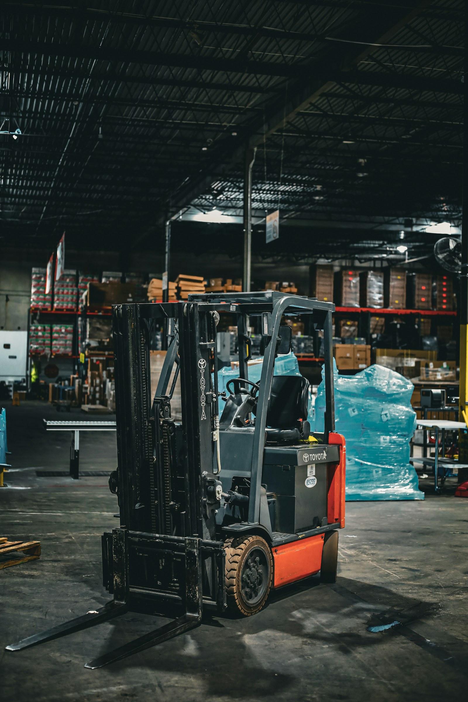Forklift parked beside packed goods in a warehouse